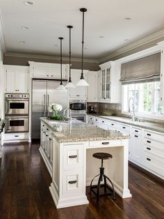 a large kitchen with white cabinets and an island in the middle is featured on instagram