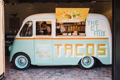 the food truck is decorated with an orange and blue stripe on it's side