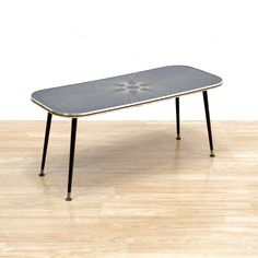 a table that is sitting on top of a wooden floor in front of a white wall