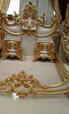 an ornate gold bed frame with matching footboard and headboard is shown in front of the mirror