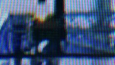 a blurry image of a person standing in front of a tv screen