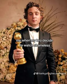 a man in a tuxedo holding an award for best performance by an actor