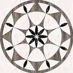 a black and white drawing of a flower in a circular design on a wood background