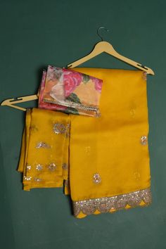 Be a vision of elegance at weddings and parties in this mango yellow embroidered organza sari. It comes with a matching and multicolor blouse piece. Shop designer sarees online in USA from Pure Elegance. DISCLAIMER:- The shown stitched blouse on the model is for display purpose only. The saree comes with a matching blouse piece and finished with fall and piko.