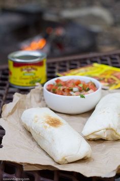 burritos and salsa are sitting on a grill