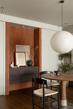 a dining room table with two chairs and a vase on top of the table in front of it