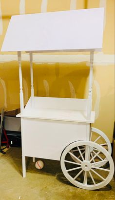 a white cart sitting in front of a yellow wall