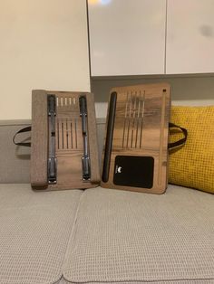 two wooden trays sitting on top of a couch