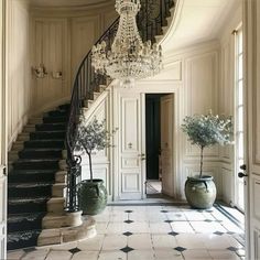 an elegant foyer with chandelier and vases