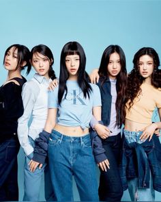 group of young women standing in front of a blue background