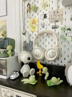 headphones are sitting on top of a shelf in front of a wall with pictures