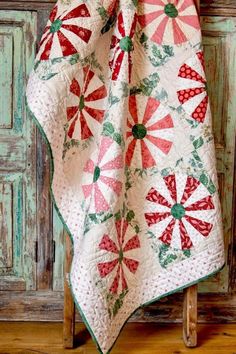 a red and white quilt on a wooden chair