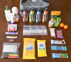 the contents of a travel bag sitting on top of a wooden table next to an orange