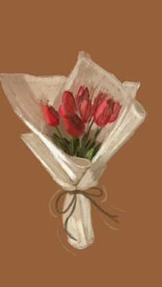 a bouquet of red tulips wrapped in white paper