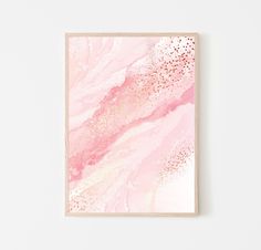 a pink and gold abstract painting on a white wall next to a wooden framed object