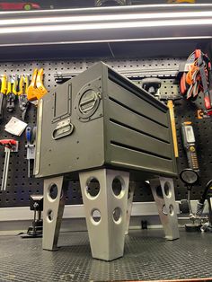 a large metal object sitting on top of a work bench in a garage filled with tools