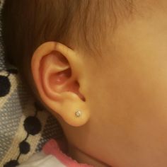 a close up of a baby's ear with a tiny diamond in the middle