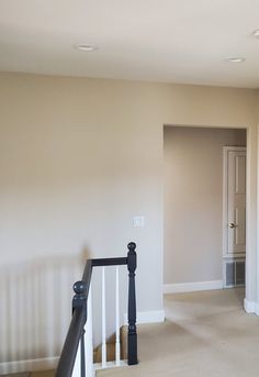 an empty room with white walls and black railing