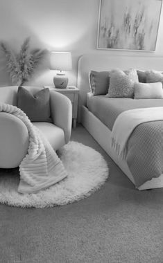 a black and white photo of a bedroom with two chairs, a bed, and a rug