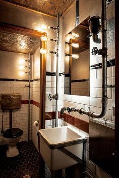 a bathroom with a sink, mirror and toilet in it's stall area at night