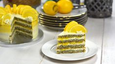 there is a slice of cake with lemons on the side and plates in front