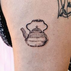 a black and white photo of a teapot tattoo