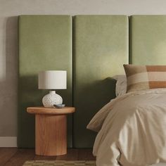 a bedroom with a bed, nightstand and green headboard