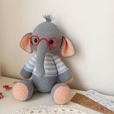 a crocheted elephant with glasses sitting on a table