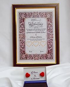 a framed wedding card with two hearts on it