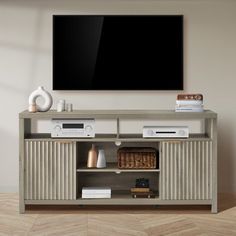 an entertainment center with a flat screen tv mounted on it's wall, in front of a wooden floor