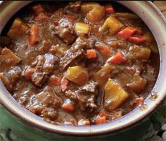 a pot filled with stew and carrots on top of a table