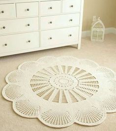 a crocheted doily is on the floor next to a dresser and drawers