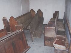 an old church with wooden pews and benches in the corner, some are empty