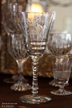 an assortment of glass goblets sitting on a table