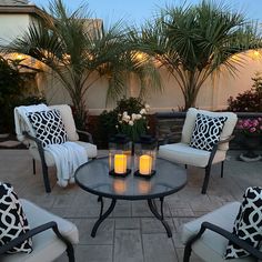 a patio with chairs, table and candles on it