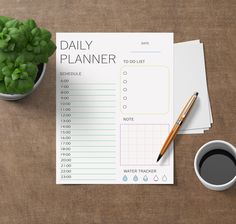 the daily planner is next to a cup of coffee and pen on a wooden table