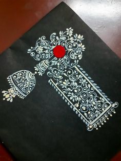 a black book with white designs and a red button on the cover sitting on a wooden table