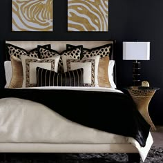 a bedroom with black and gold decor on the wall above the bed is decorated with zebra prints