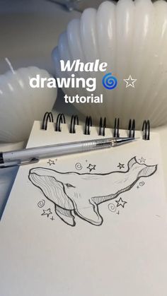 a spiral notebook with a drawing of a whale on it