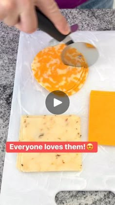 someone cutting cheese with a knife on top of a plastic bag that says everyone loves them