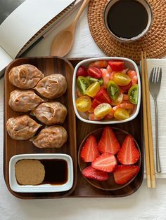 a tray filled with different types of food on top of a table next to a cup of coffee