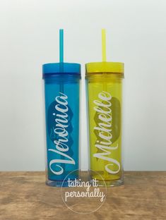 two personalized tumblers sitting on top of a wooden table next to each other