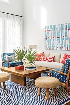 the living room is decorated in blue and white colors with pops of color on the walls