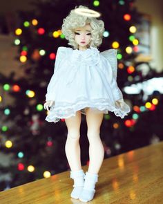 a doll is standing in front of a christmas tree