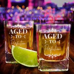 three shot glasses with lime slices on the table