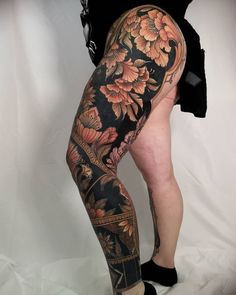 a woman's leg with tattoos and flowers on it