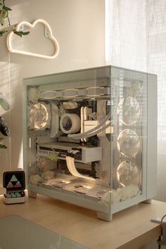 a glass case sitting on top of a wooden table next to a clock and plant