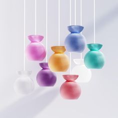 multicolored vases hanging from strings against a white background