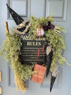 a witch's house rules sign hanging on the front door with brooms and other decorations