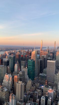 an aerial view of new york city with skyscrapers and other tall buildings at sunset